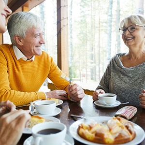 Smiling friends enjoying meal at restaurant