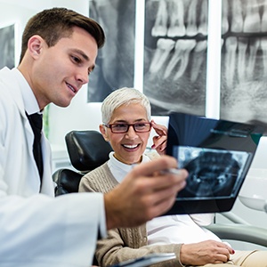 Smiling patient reviewing X-ray with dentist