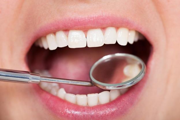 Close up of a dental mirror examining teeth