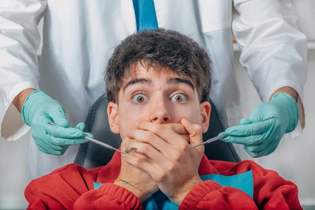 Nervous patient covering his mouth while at the dentist