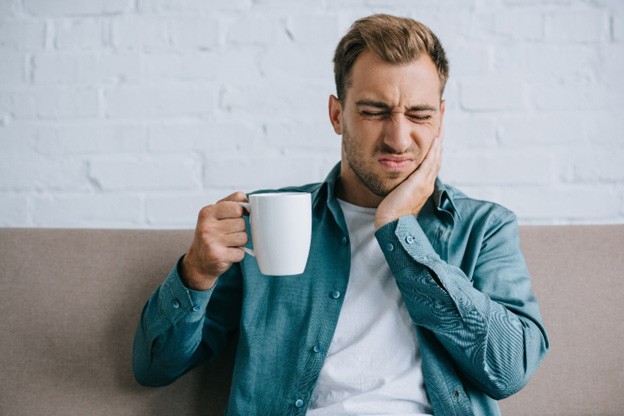 Man rubbing his jaw at his desk