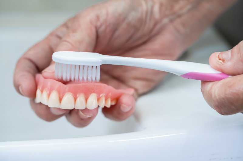 Denture being brushed