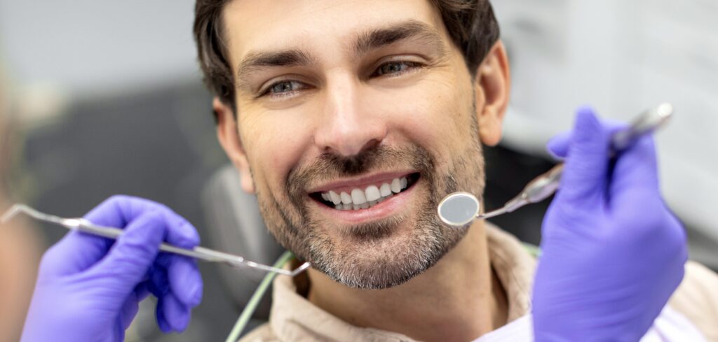 Closeup shot of dentist examining male patients teeth in dental clinic. Man having his teeth examined by female dentist