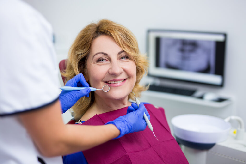 portrait of cheerful mature woman patient in dental clinic