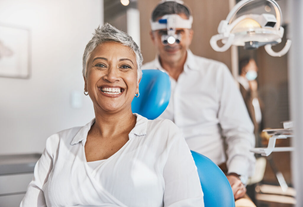 Portrait, hAappy and dental with a woman patient in a doctor office for oral hygiene or health. Smile, teeth and healthcare with a senior female sitting in a chair at the dentist for hygiene.