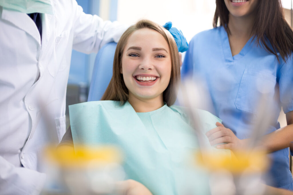 Happy girl in dental chair after treatment when pain stopped in clinic