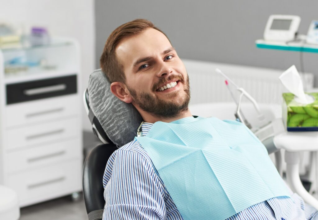 Portrait of happy patient in dental chair. Modern dentistry with the use of new technologies