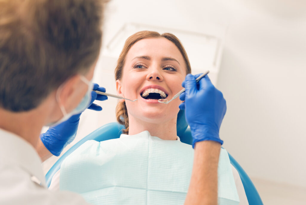 Thank you for helping. Top view on a positive minded female patient relaxing on a dental chair and looking at a dental professional with her eyes full kindness