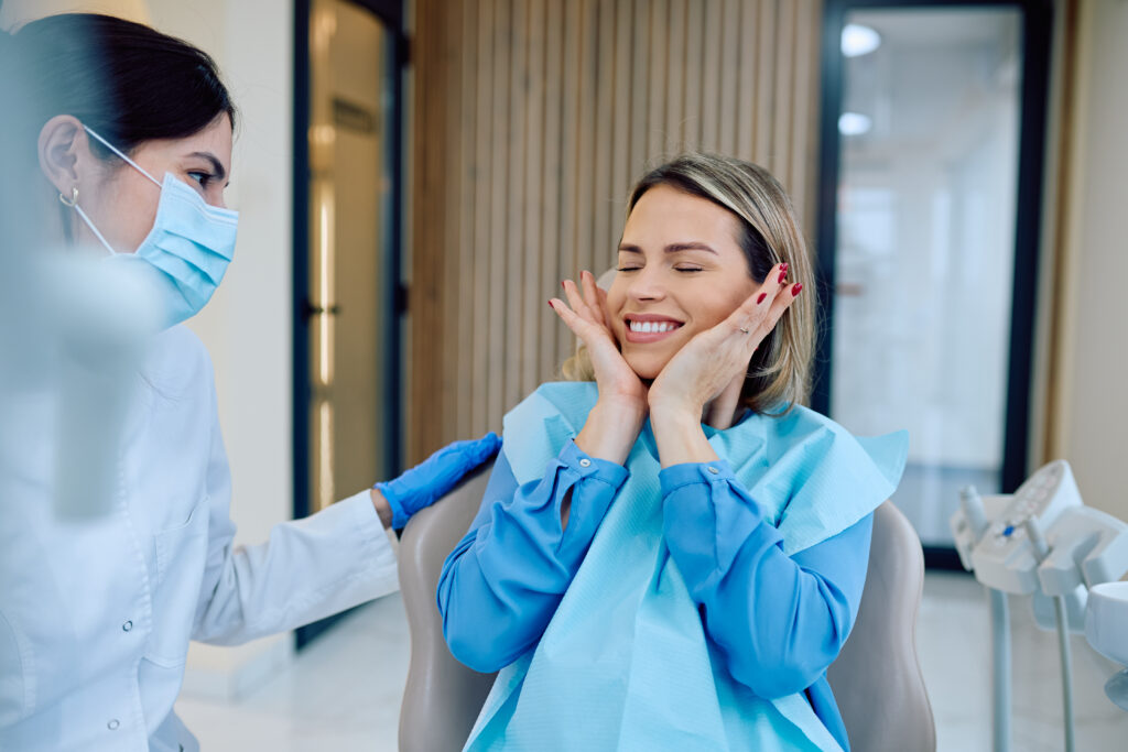 Patient feeling happy seeing new smile with dentist
