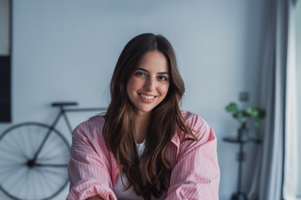 Happy pretty millennial girl home head shot portrait. Young confident business woman in casual, entrepreneur, blogger posing at home office workplace table enjoying indoor, smiling at camera