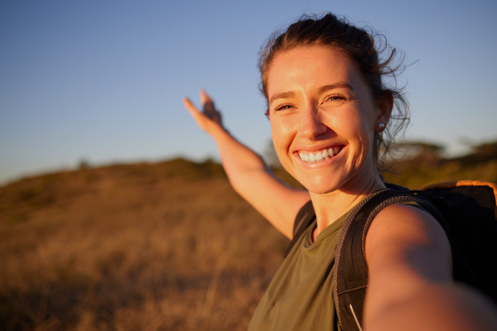Shot of a young woman taking a selfie while out hiking.