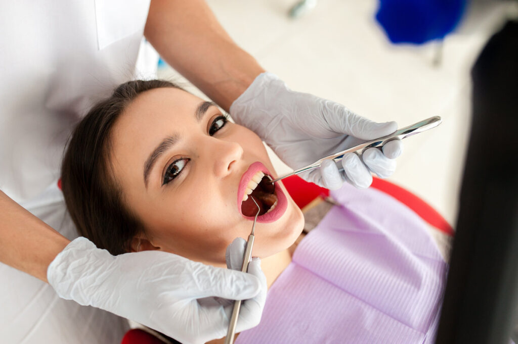 Beautiful girl treats teeth in dentistry.