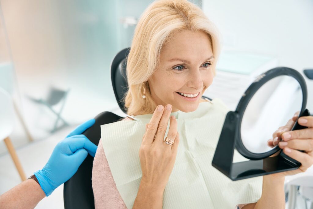 Prosthodontist consulting with a smiling patient during a dental appointment in Naples