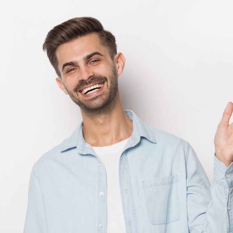 Close up head shot portrait handsome man showing high five gesture. Happy client waving hand in greeting gesture and looking at camera, giving high five to friend, isolated on gray studio background.