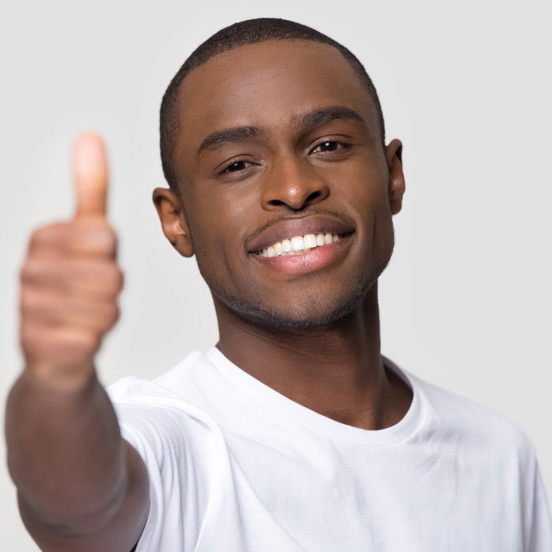 Close up face of happy African American man showing thumbs up, head shot portrait satisfied male with healthy white smile looking at camera, client recommend service, isolated on studio background